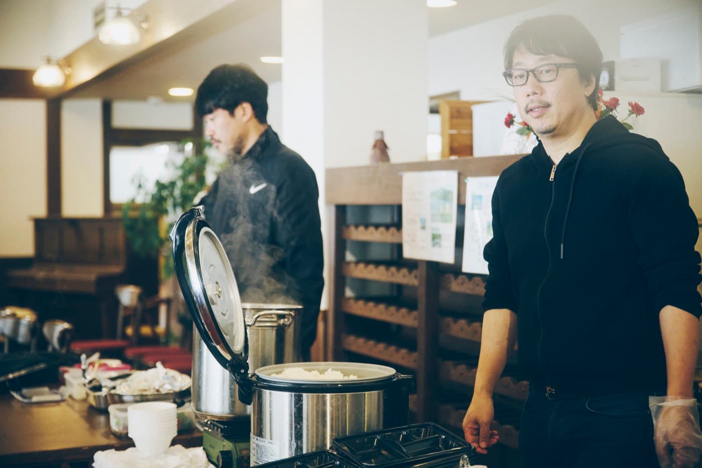釜のそばで微笑むプロデューサーの山本晃久さん